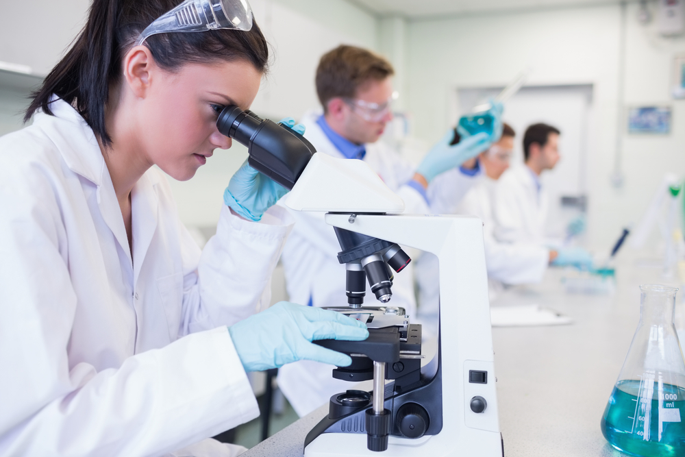Side view of busy group of researchers working on experiments in the laboratory Side view of busy group of researchers working on experiments in the laboratory